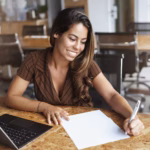 successful-hispanic-woman-smiling-working-cafe_197531-22828
